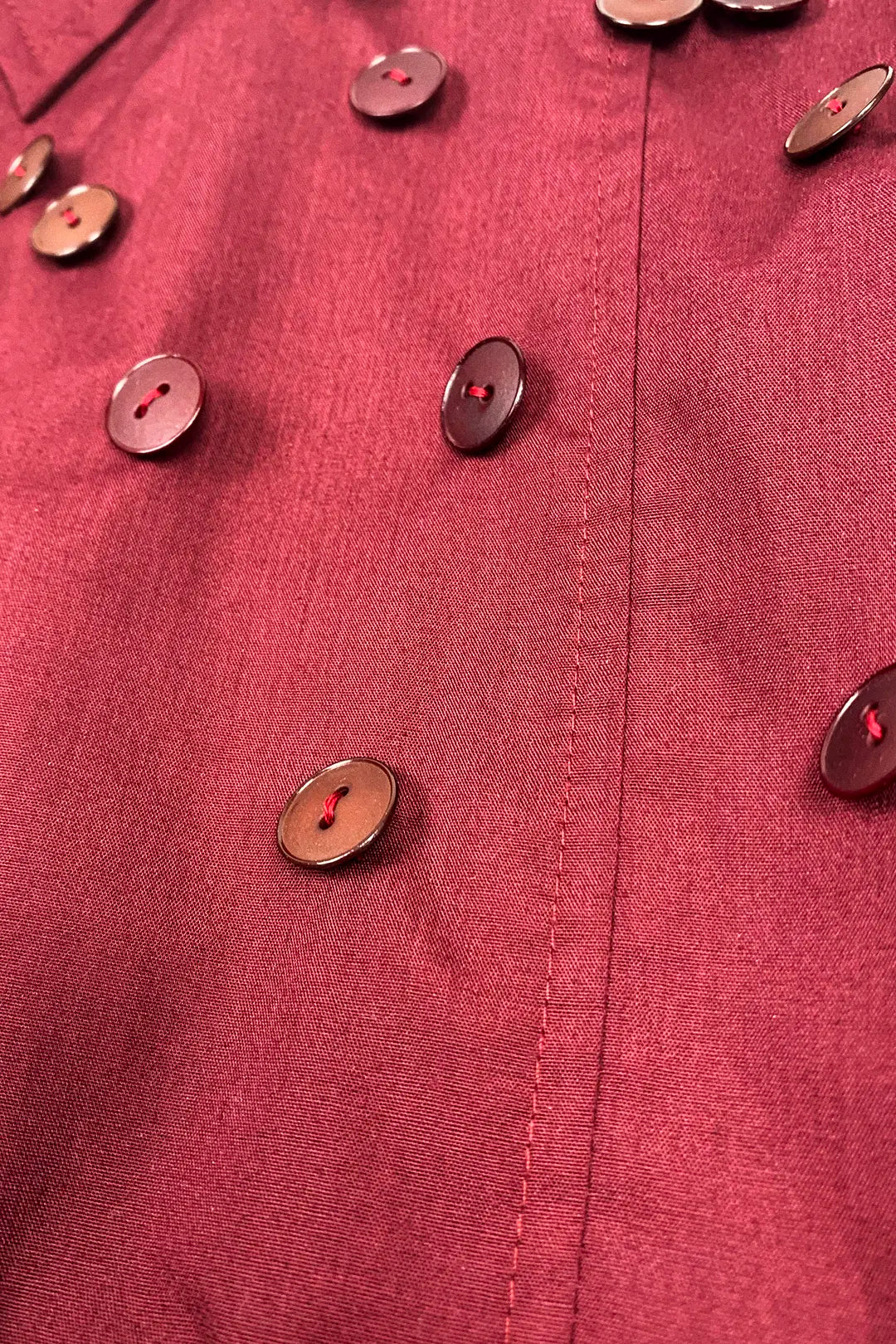 Close-up of a burgundy cotton fabric with buttons