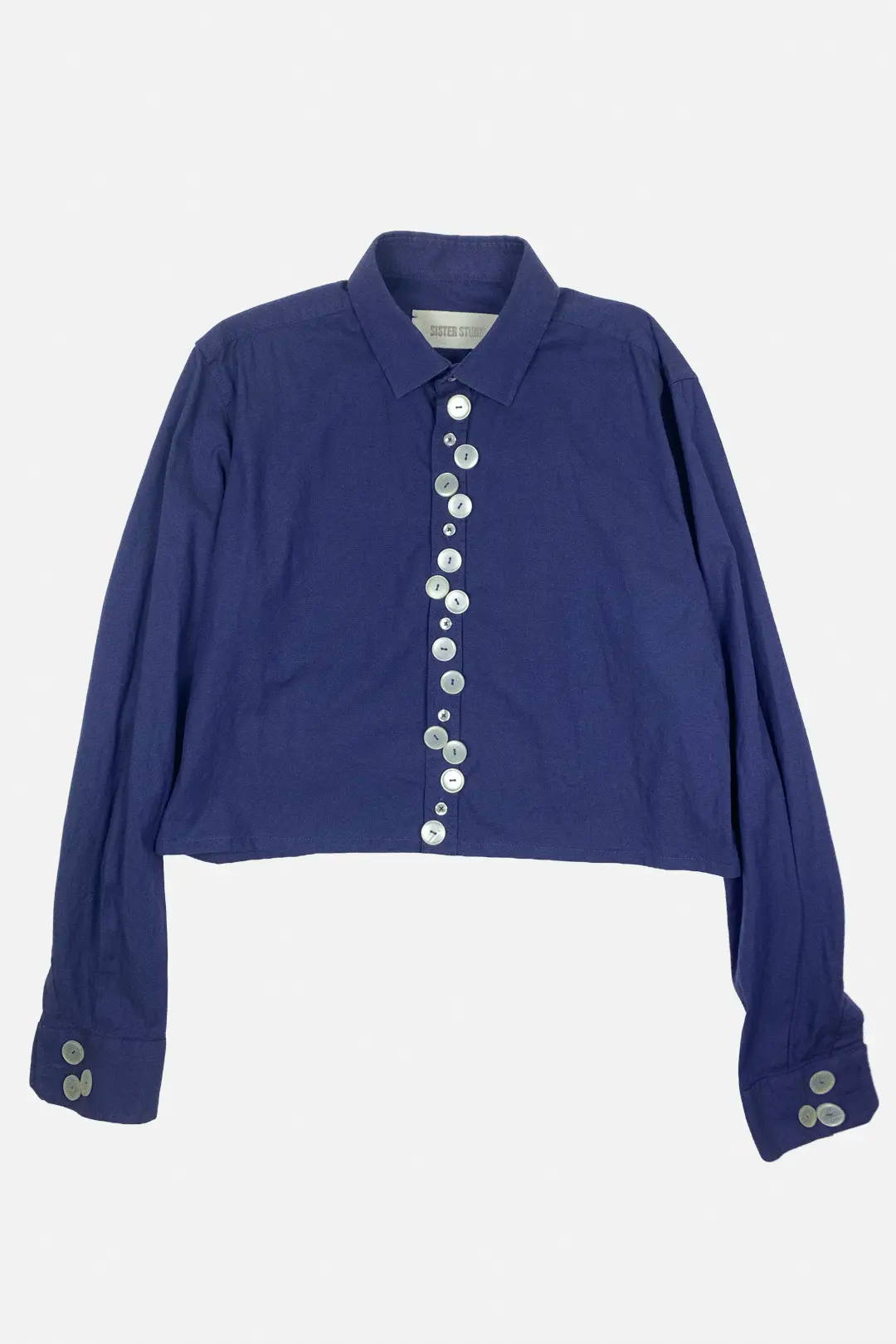 Blue shirt with beige buttons on a light gray background