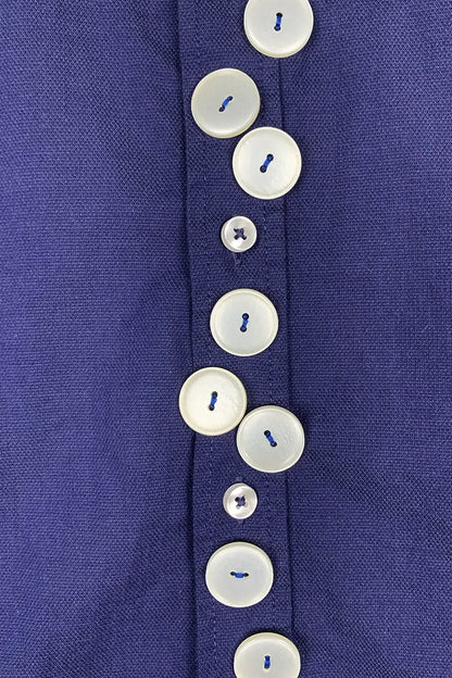 Close-up of a blue shirt with beige buttons