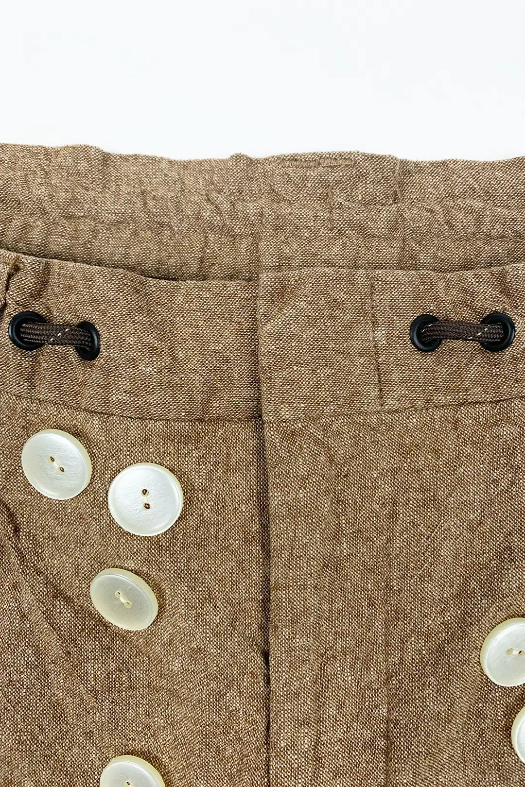 Close-up of brown fabric with buttons on a white background