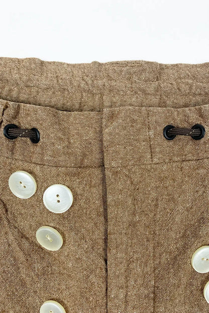 Close-up of brown fabric with buttons on a white background