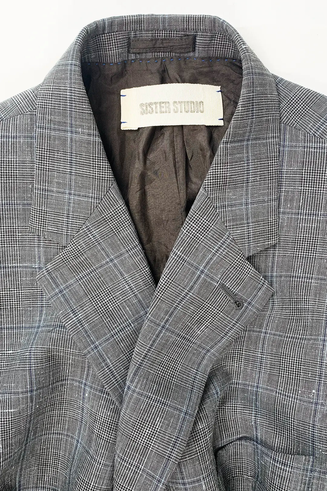 Gray checkered blazer with 'Sister Studio' label on a white background