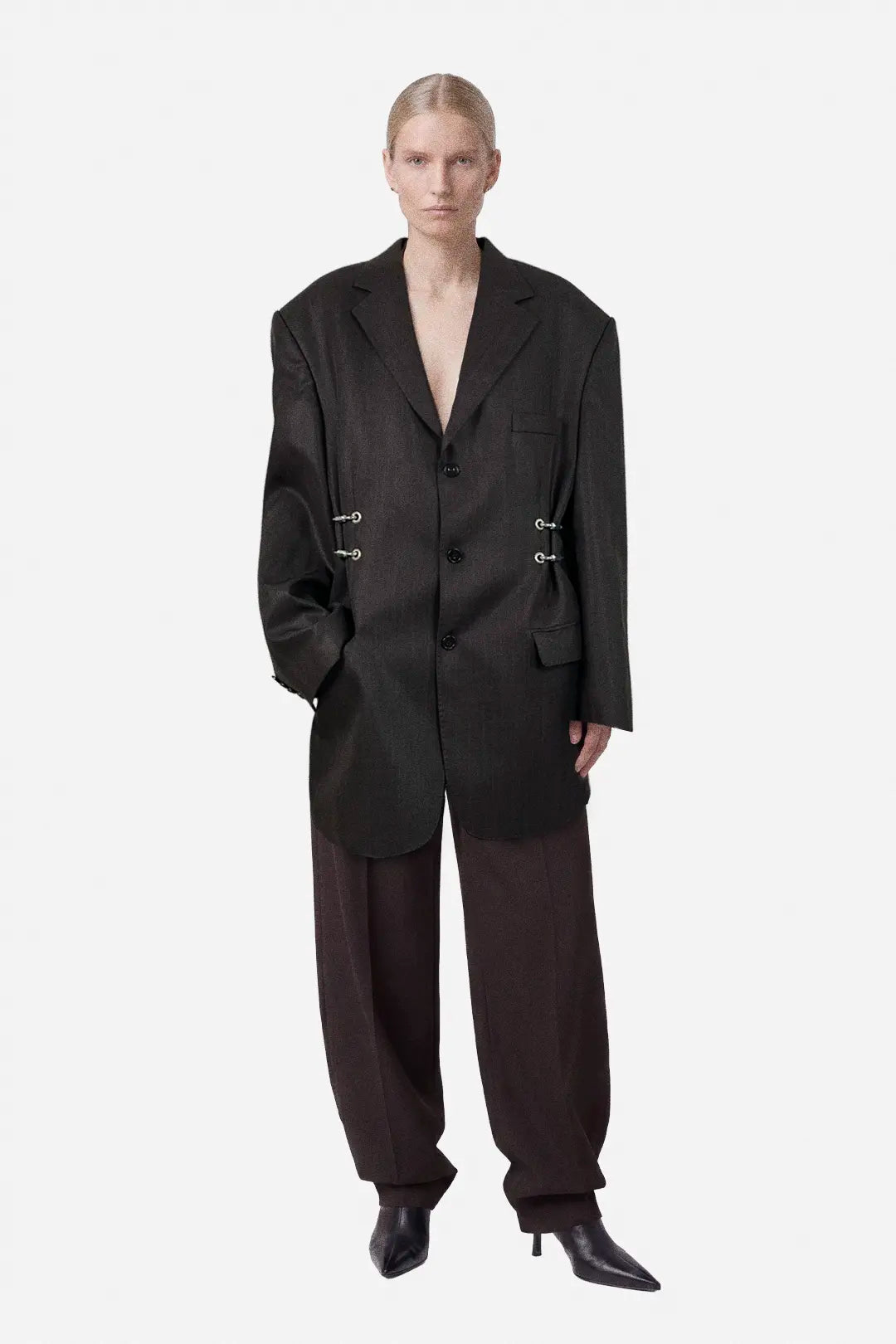 Person wearing a brown oversized blazer on a white background