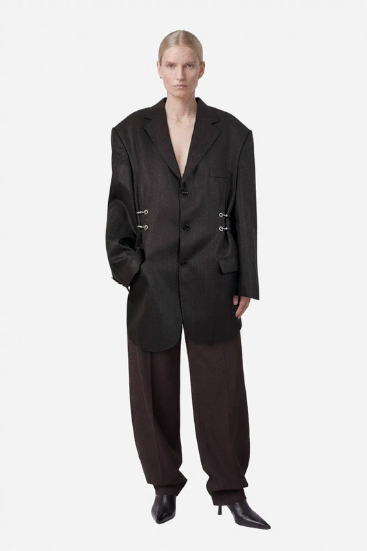 Person wearing a brown oversized blazer on a white background