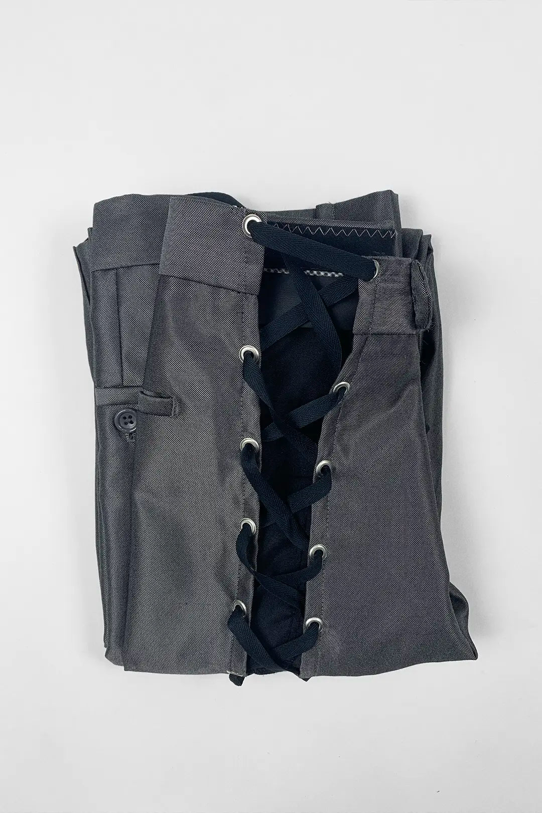 A folded dark gray garment with a front lace-up closure and silver metal eyelets, photographed on a plain light background.