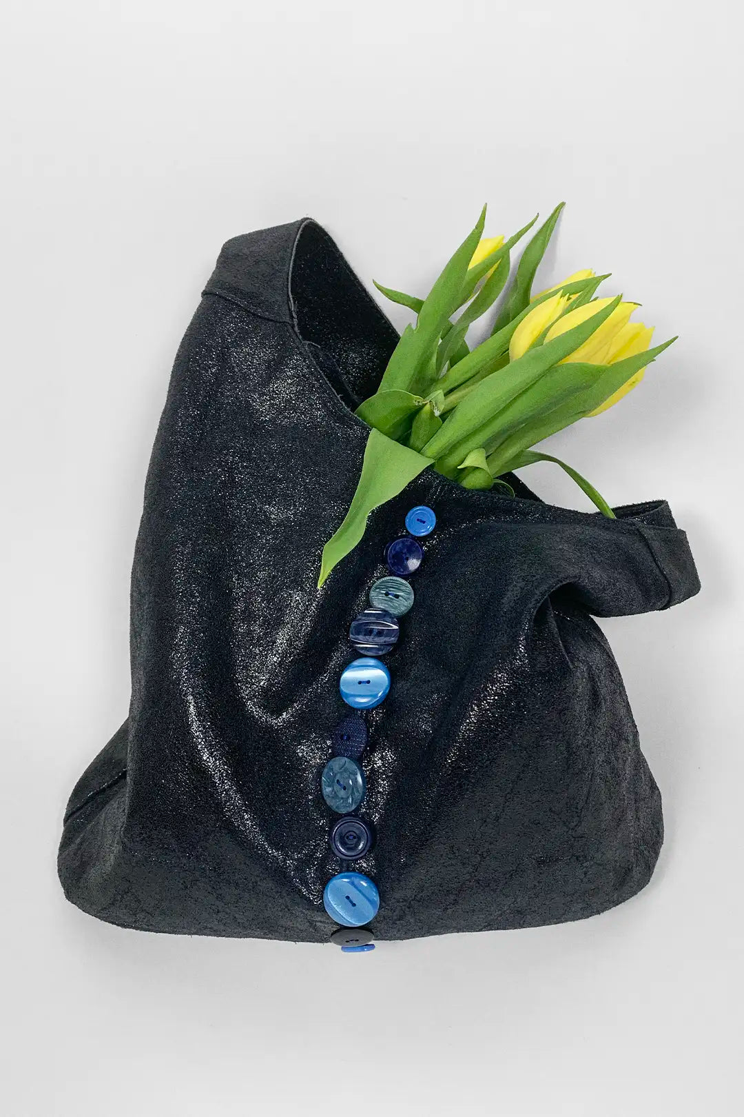 navy bag with blue buttons and yellow flowers on a white background