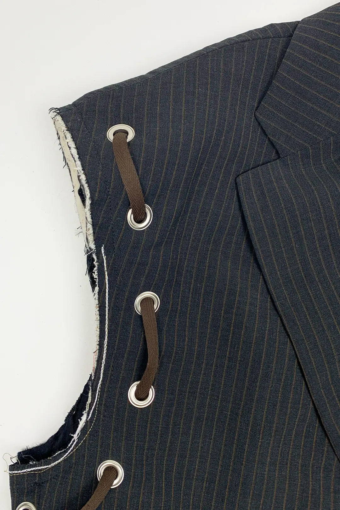 Close-up of a dark pinstripe suit jacket with button details on a white background