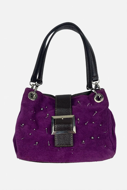 A purple suede handbag with black faux-leather trim, silver-tone hardware, and small silver studs, shown against a plain light gray background.