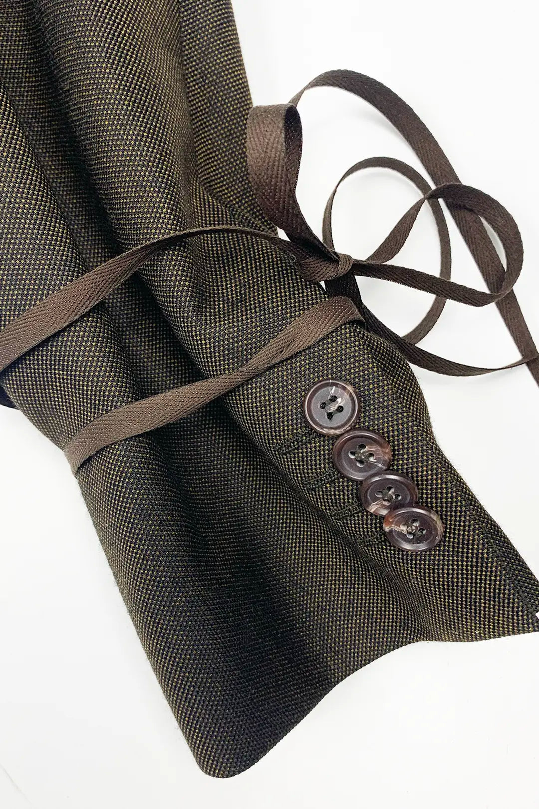 Brown textured fabric with buttons and ribbons on a white background